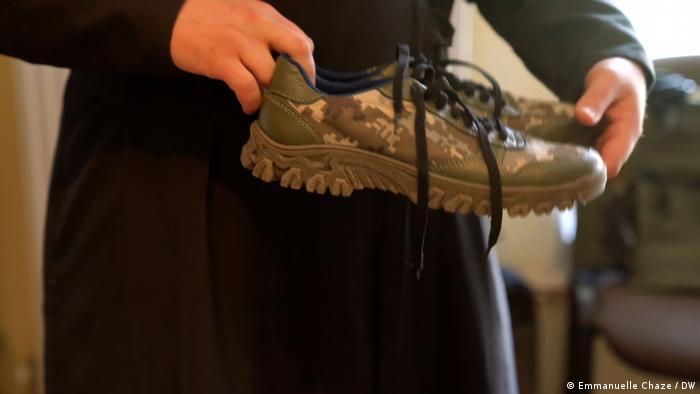 Фото без даты: монах из монастыря в Ивано-Франковске держит в руках обувь для военнослужащих ВСУ