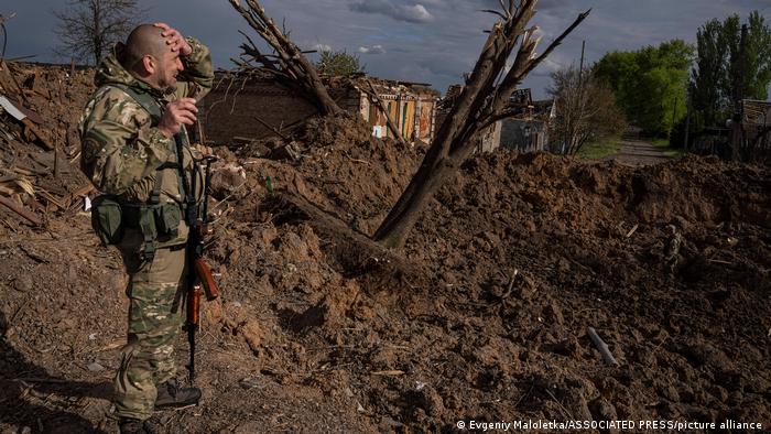 Солдат ВСУ оценивает последствия авиаудара в городе Бахмут, Донецкая область. Фото сделано 10 мая 2022 года
