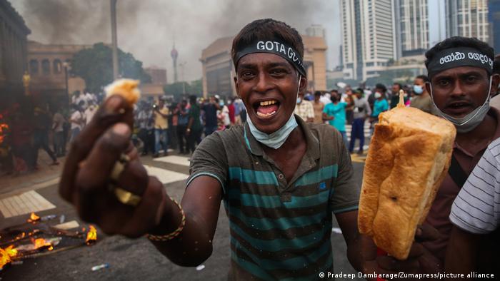 Один из протестующих в Шри-Ланке показывает в камеру кусок хлеба, 15 марта 2022 года