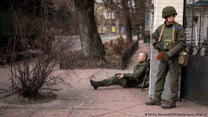 Раненый военнослужащий украинской армии сидит на улице Киева 24 февраля 2022 года