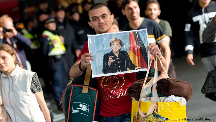 Беженцы с фотографиями Меркель на вокзале в Мюнхене 